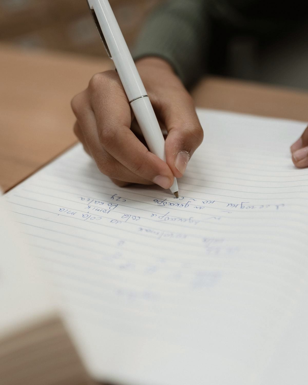 A hand working an idea out on paper, before any of it becomes software.